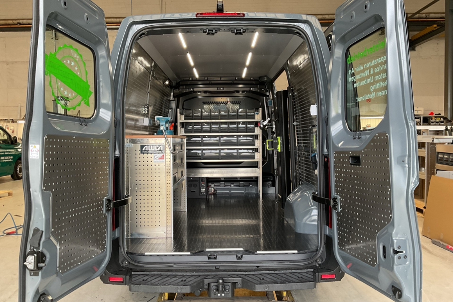 Caramo GmbH Projekt mobile Fahrradwerkstatt. Zu sehen ist das Nutzfahrzeug in unserer großen Werkstatt in Kaltenkirchen. eine Arbeitsfläche und Fahrzeugeinrichtung von Aluca.